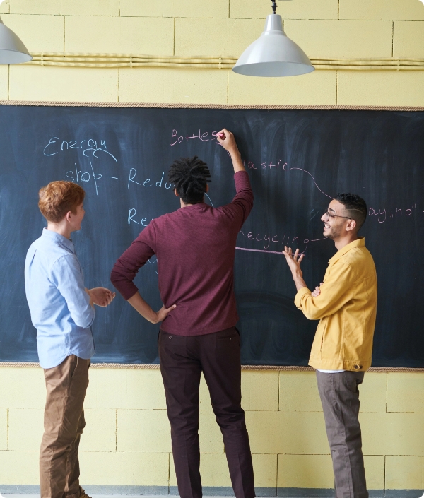 Imagen artículo blog bajo el título "Una nueva cultura" | Imagen de tres jóvenes debatiendo ideas en la pizarra de clase