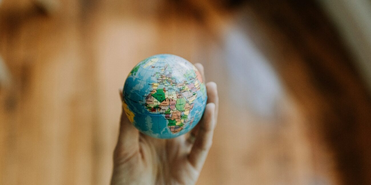 Entrada artículo blog bajo el título "Emprendimiento social" | imagen que muestra el detalle de una mano cogiendo una pequeña bola del mundo