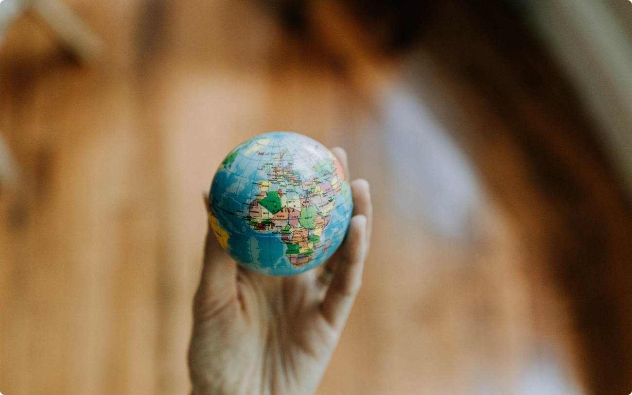 Entrada artículo blog bajo el título "Emprendimiento social" | imagen que muestra el detalle de una mano cogiendo una pequeña bola del mundo